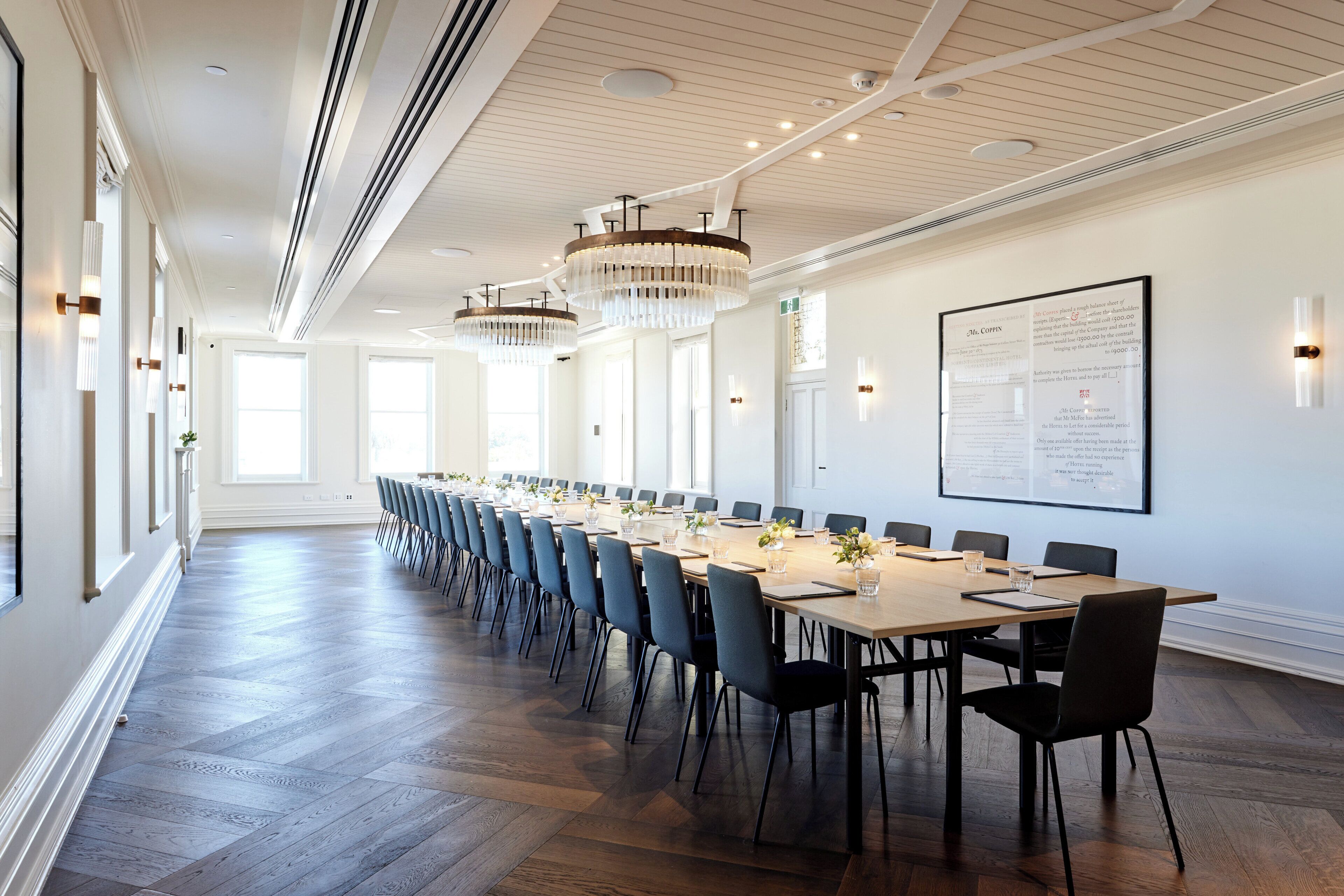 A conference room with a long table, chairs, and a whiteboard.
