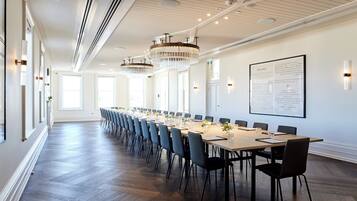 A conference room with a long table, chairs, and a whiteboard.