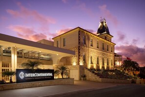 Un hôtel à la façade en pierre, doté d’une aile moderne et d’une enseigne indiquant « INTERCONTINENTAL SORRENTO MORNINGTON PENINSULA ».