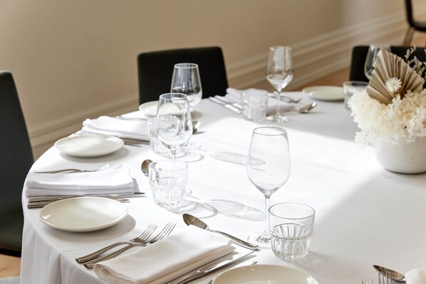 A neatly set dining table with white tablecloth, plates, cutlery, and clear glasses. - InterContinental Sorrento Mornington Peninsula by IHG (Sorrento)