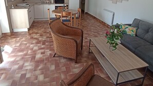 Ett modernt vardagsrum med en soffa, ett soffbord och två fåtöljer i rotting.