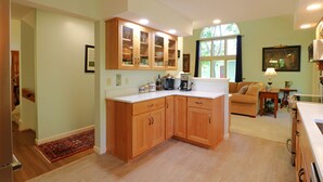 A kitchen with wooden cabinets, a countertop, and a window.