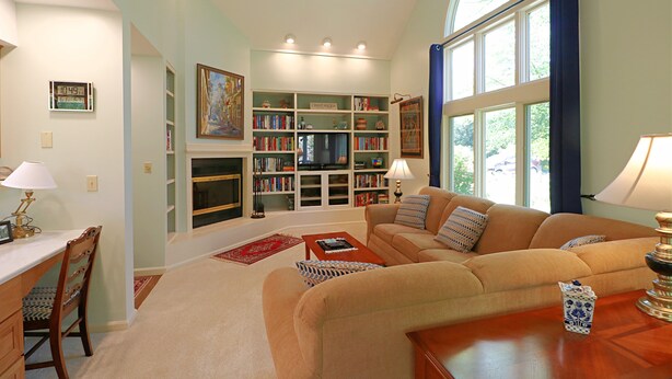 A living room with a sofa, coffee table, and a bookshelf filled with books.