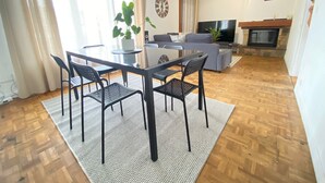 Una sala de estar con comedor, televisión y chimenea.