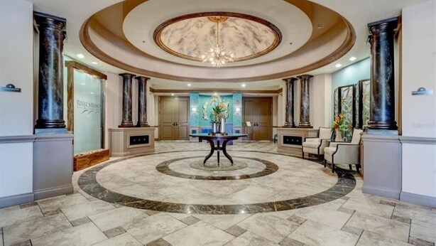 Eine prachtvolle Lobby mit Marmorboden, einem zentralen Tisch und einem Chandelier.