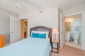 Une chambre à coucher comprenant un lit, une table de chevet et une salle de bain avec des toilettes et un lavabo.