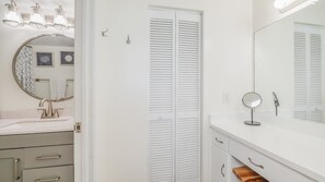 Baño con lavabo, espejo y toallero.