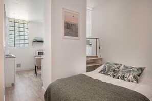 A modern bedroom with a bed, a desk, and a chair.