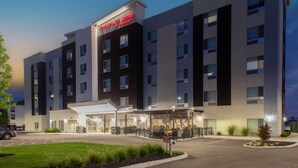 A modern hotel with a sign reading "Townplace Suites by Marriott" and a covered outdoor area with seating. - TownePlace Suites by Marriott Dayton Wilmington (Wilmington)