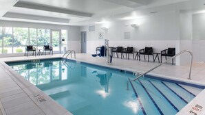 An indoor swimming pool with clear lane markings, a pool lift, and seating areas with chairs. - TownePlace Suites by Marriott Dayton Wilmington (Wilmington)