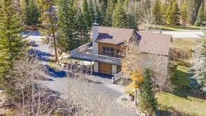A single-story house with a chimney, surrounded by a forested area. - 4515 Bighorn Rd. 4 Bedroom Home by RedAwning (Vail)