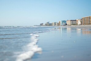 A beach with a clear sky, waves, and buildings in the background. - The Oasis Retreat +Pool +Game Room +Basketball + Massive Yard +Near Beach & Golf (Largo)