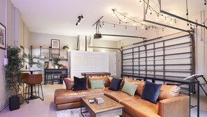 A modern living room with a sectional sofa, a coffee table, and a dining area with chairs. - The Oasis Retreat +Pool +Game Room +Basketball + Massive Yard +Near Beach & Golf (Largo)