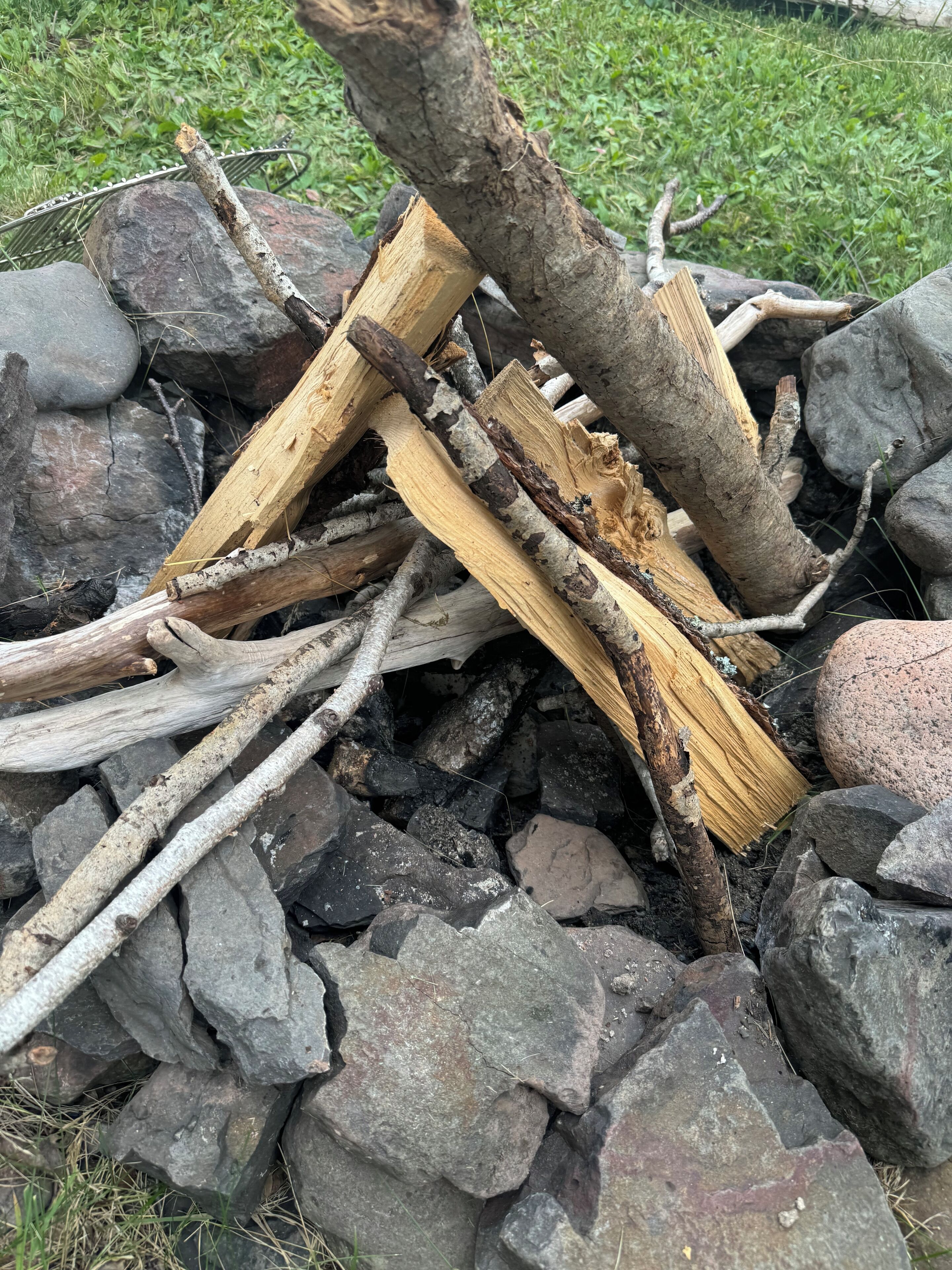 Ein Haufen Holzscheite und Äste in einer felsigen Landschaft.