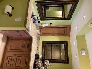 Enjoy a clean and functional bathroom with a granite countertop, large mirror, and ample storage space.