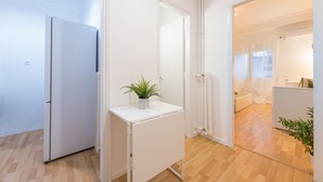 A modern kitchen with a refrigerator, a small white cabinet, and a potted plant. - Apartment at Megaro Mousikis metro station 1bed 2 pers (Athens)