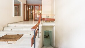 A staircase with a wooden handrail leading to a landing. - Apartment at Megaro Mousikis metro station 1bed 2 pers (Athens)