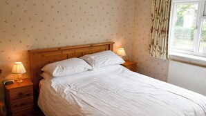 A neatly made bed with white linens, a wooden headboard, and two bedside lamps. - 1 bedroom accommodation in Gillamoor, near Kikbymoorside (Gillamoor, near Kikbymoorside)