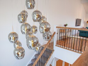 A staircase with a wooden handrail and a metal railing, leading to an upper level.