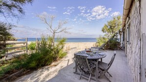 A patio with a table and chairs overlooking a beach. - Le Pescadou - Terrasse vue mer (Marseille)