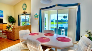 Comedor con mesa, sillas y vista a una piscina.