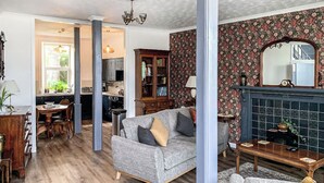 Un salon avec un canapé gris, un meuble en bois et une cheminée.