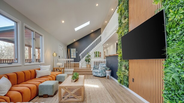 A modern living room with a sectional sofa, a coffee table, and a staircase leading to an upper level. - Private Pool- Hot Tub- Playground- Fire Pit- Fenced In Backyard- Pets! (Pocono Mountains)