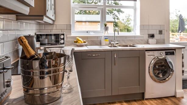 Una cucina moderna con lavatrice integrata, forno a microonde e un'ampia finestra.