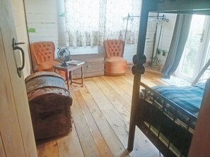 A room with a bed, a chair, a table with a globe, and a window with curtains. - 2 bedroom accommodation in Dungeness (Dungeness)