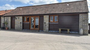 A two-story building with a tiled roof, a stone facade, and a wooden door. - 2 bedroom accommodation in Catsham, near Glastonbury (Catsham, near Glastonbury)
