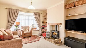 Una sala de estar acogedora con chimenea, televisor y asientos cómodos.