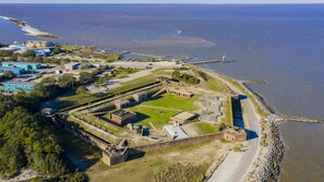 An aerial view of a coastal fort with a large central courtyard, surrounded by a fortified wall and a beach. - East End Beach Side Bungalow (Dauphin Island)