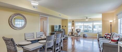 A spacious living area with a dining table, chairs, and a sofa.