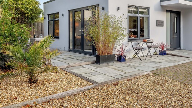 A modern building with large windows, a patio area with seating, and a variety of plants. - 1 bedroom accommodation in Boscombe, near Bournemouth (Boscombe, near Bournemouth)