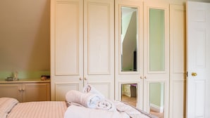 Une chambre à coucher avec un lit, une commode et un placard doté d’un miroir.