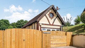 A cottage with a wooden gate, a garage, and a sign reading "Gainsborough Cottage".