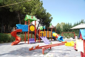 A playground with slides, climbing structures, and a seesaw.