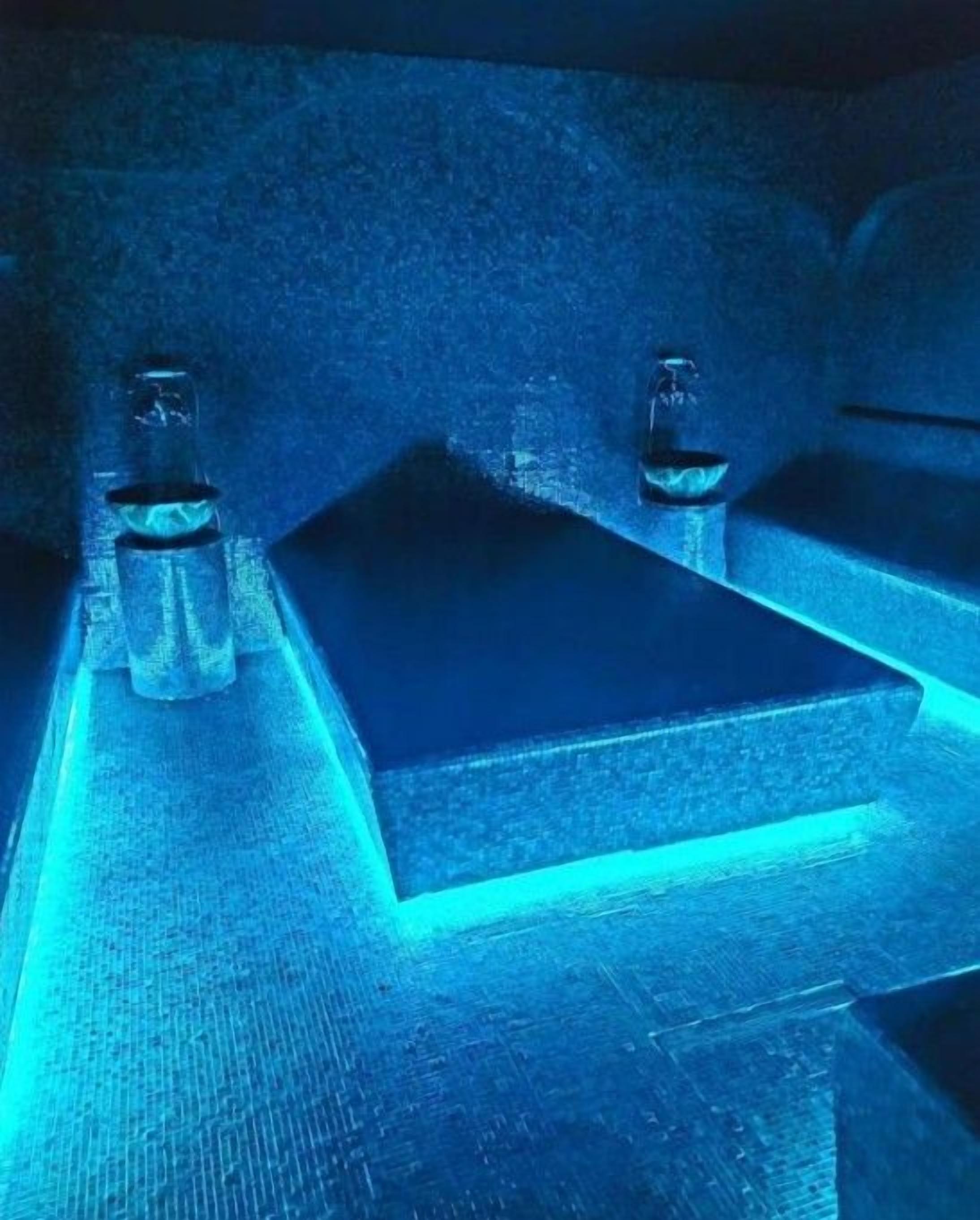 A close-up of a metallic surface with a blue light source.