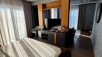 Una habitación de hotel moderna con una cama grande, un escritorio y una televisión.