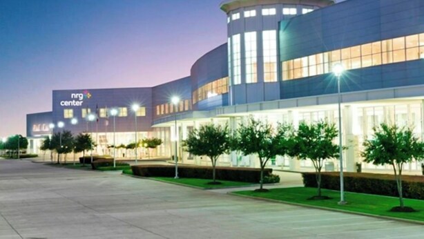 Un bâtiment moderne avec une enseigne indiquant « nrg Center » et un parking bordé d’arbres.