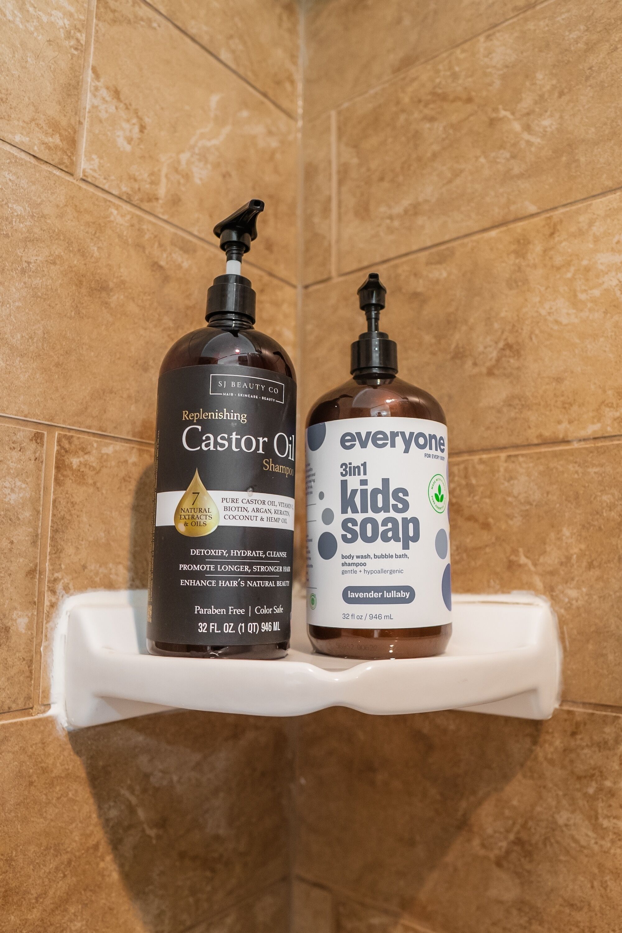 Two bottles of shampoo on a white shelf against a tiled wall.