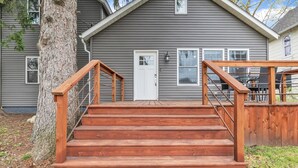 A wooden staircase leading to a gray house with a white door and windows. - Contemporary, cozy,  hidden gem close to wineries (Buchanan)