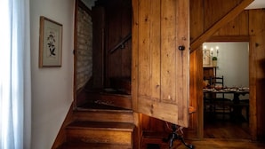 A wooden staircase leading to a dining area with a chandelier.
