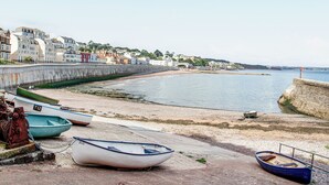 Une ville côtière dotée d’une promenade, de bateaux et de bâtiments qui bordent la côte.