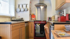A compact kitchen with wooden cabinets, a built-in oven, and a microwave. - 2 bedroom accommodation in near Windermere (near Windermere)