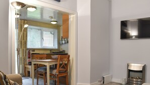 A compact living space with a kitchenette, a dining area, and a seating area with a sofa and a chair. - 2 bedroom accommodation in near Windermere (near Windermere)