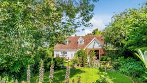 A house surrounded by lush greenery and a well-maintained garden. - Beautiful house, peaceful surrounding yet close to towns and beaches. (Faversham)