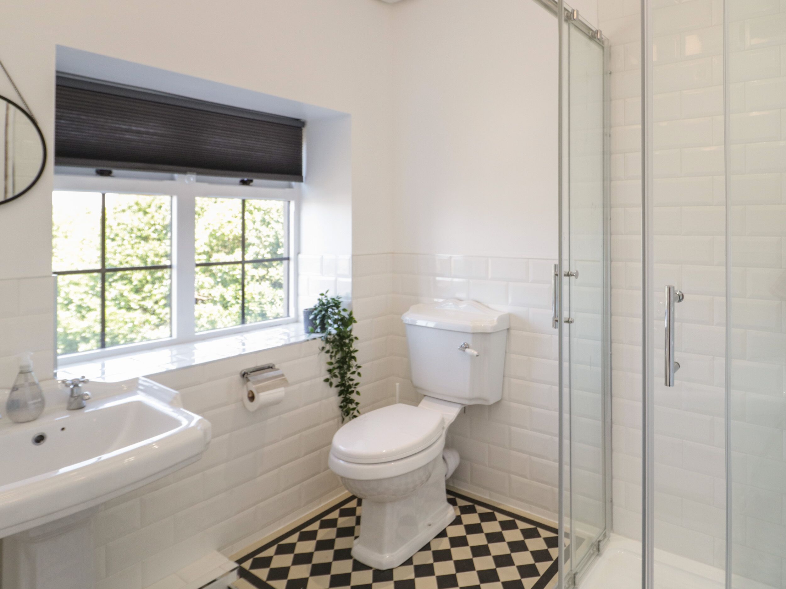 A bathroom with a white sink, toilet, and shower.
