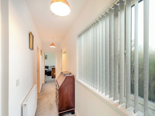 A hallway with a radiator, a wooden dresser, and a window with vertical blinds. - 2 bedroom accommodation in Codnor, near Ripley (Codnor, near Ripley)