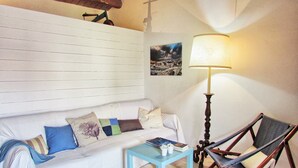 A cozy living room with a white sofa, a blue coffee table, a wooden floor lamp, and a framed picture on the wall. - SR-G267-LENZ21A1 - Dimora Il Balcone Barocco (Palazzolo Acreide)